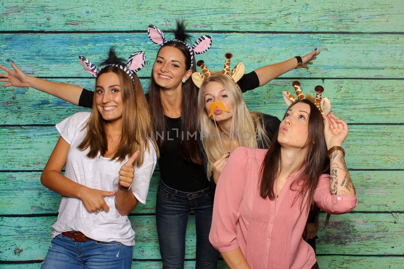 Young women silly in front of a photo box