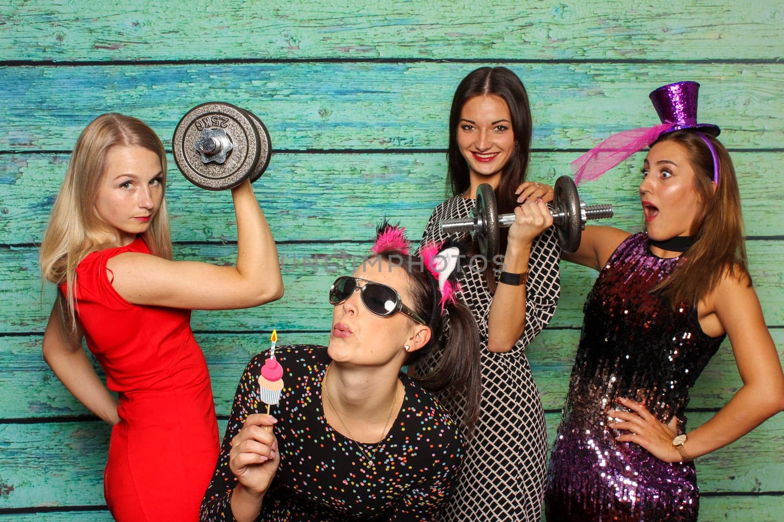 Young girls with dumbbells in front of photo box