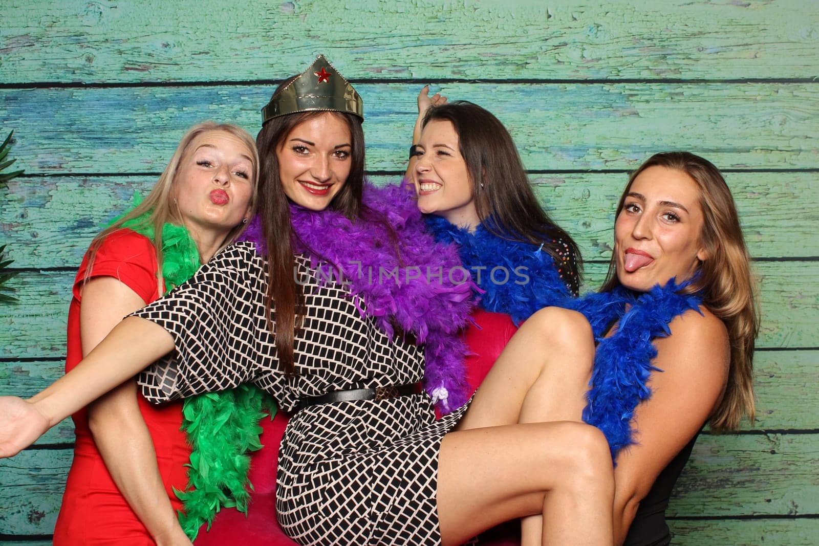 Young girls silly around in front of a photo box