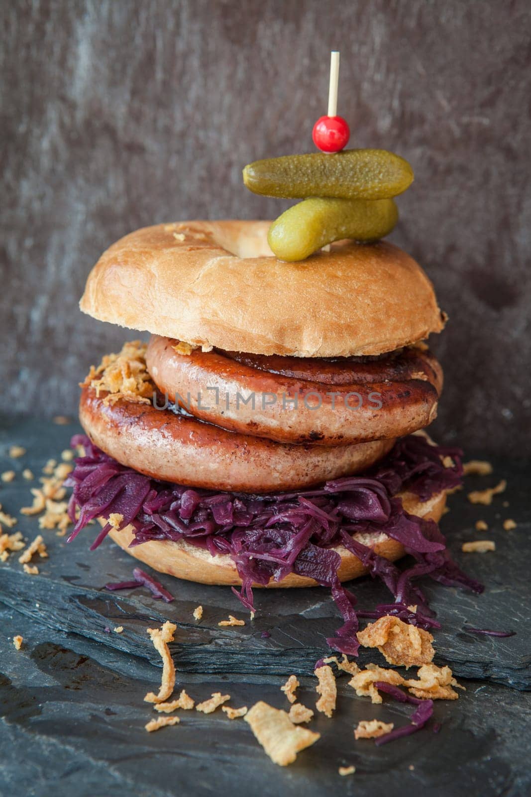 Grilled bratwurst in a broetchen with red cabbage and roestz onions