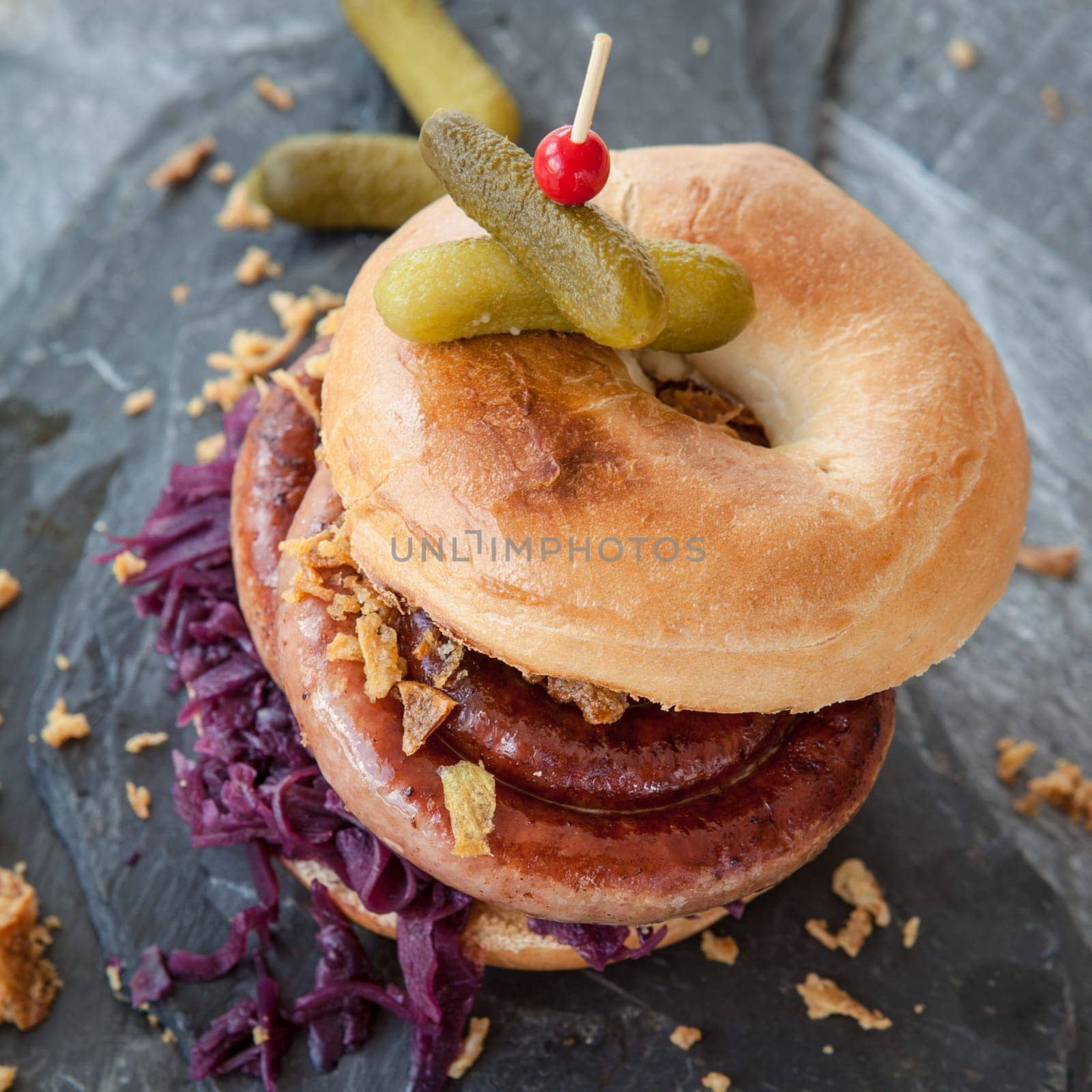 Grilled bratwurst in a broetchen with red cabbage and roestz onions