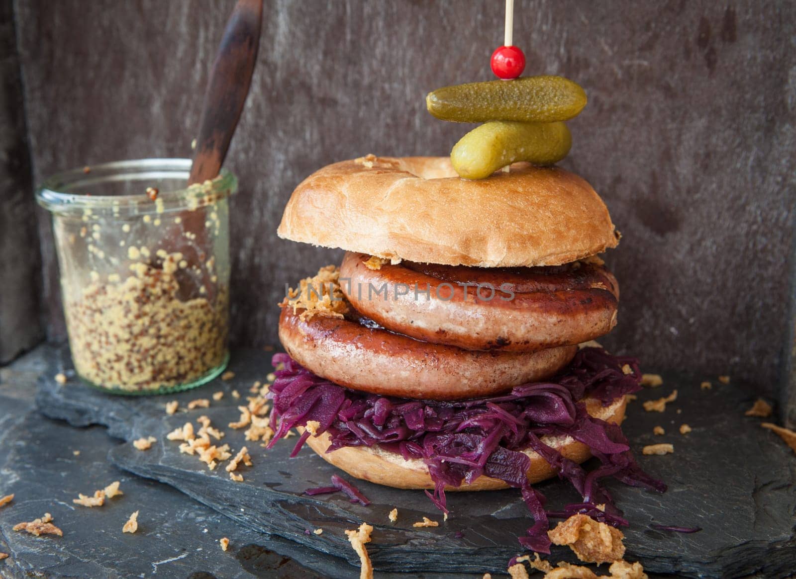Grilled bratwurst in a broetchen with red cabbage and roestz onions