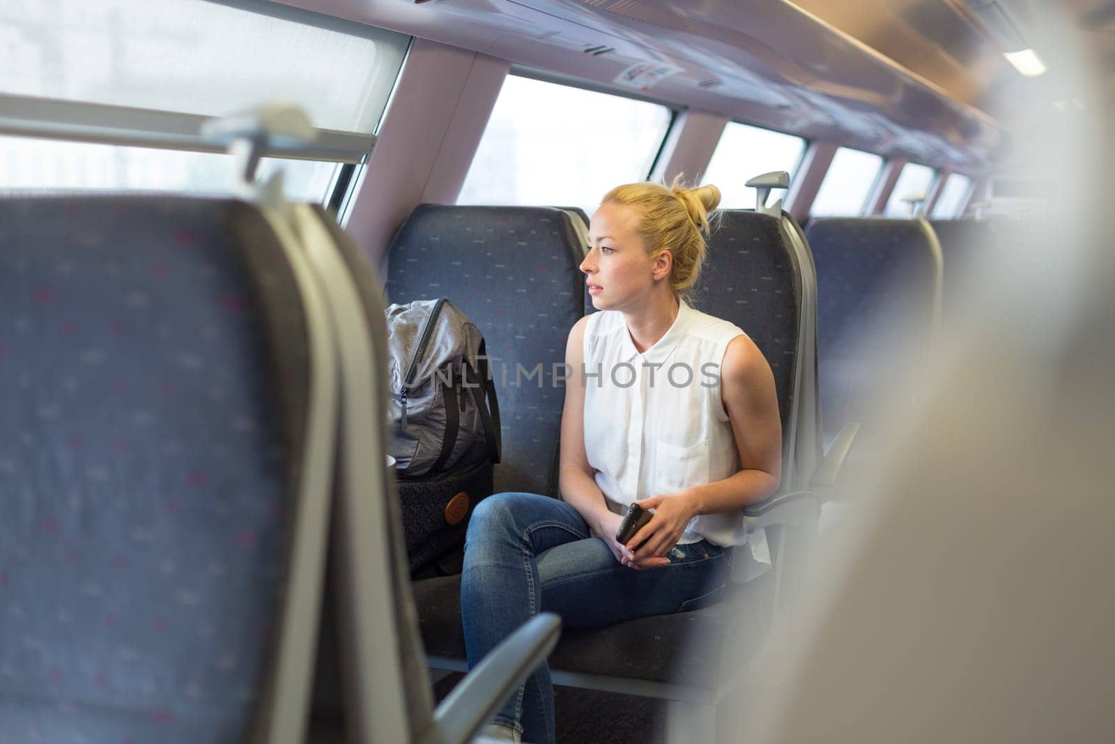 Young woman looking trough window while traveling by train.
