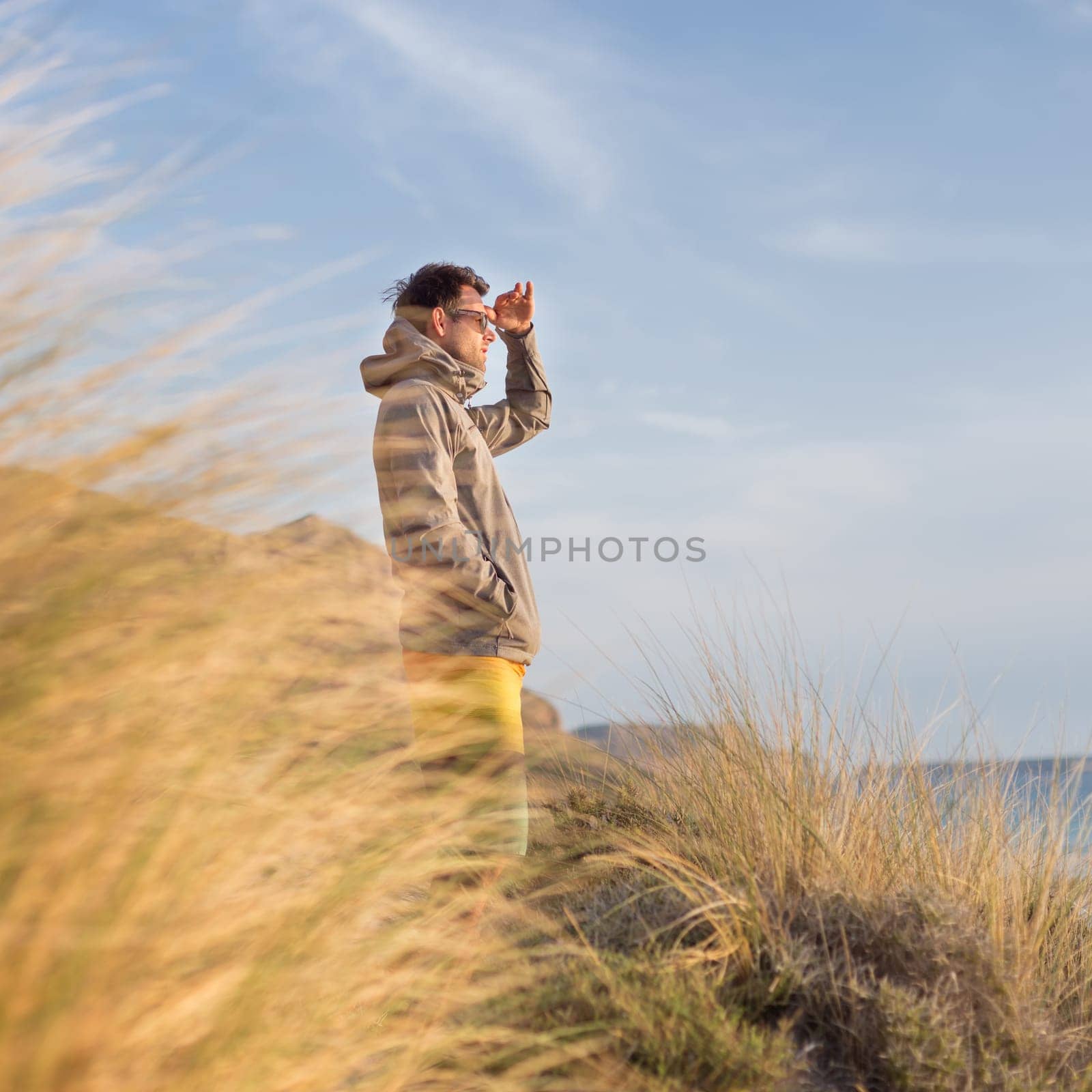 Sporty active man looking at distance, enjoying beautiful nature, freedom and life at serene landscape at Balos beach. Active lifestyle outdoors.