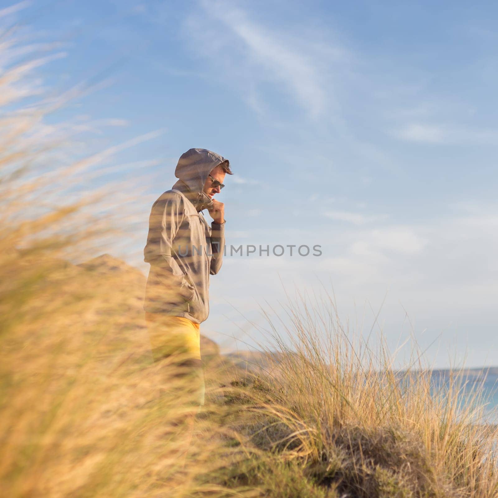 Sporty active man looking at distance, enjoying beautiful nature, freedom and life at serene landscape at Balos beach. Active lifestyle outdoors.