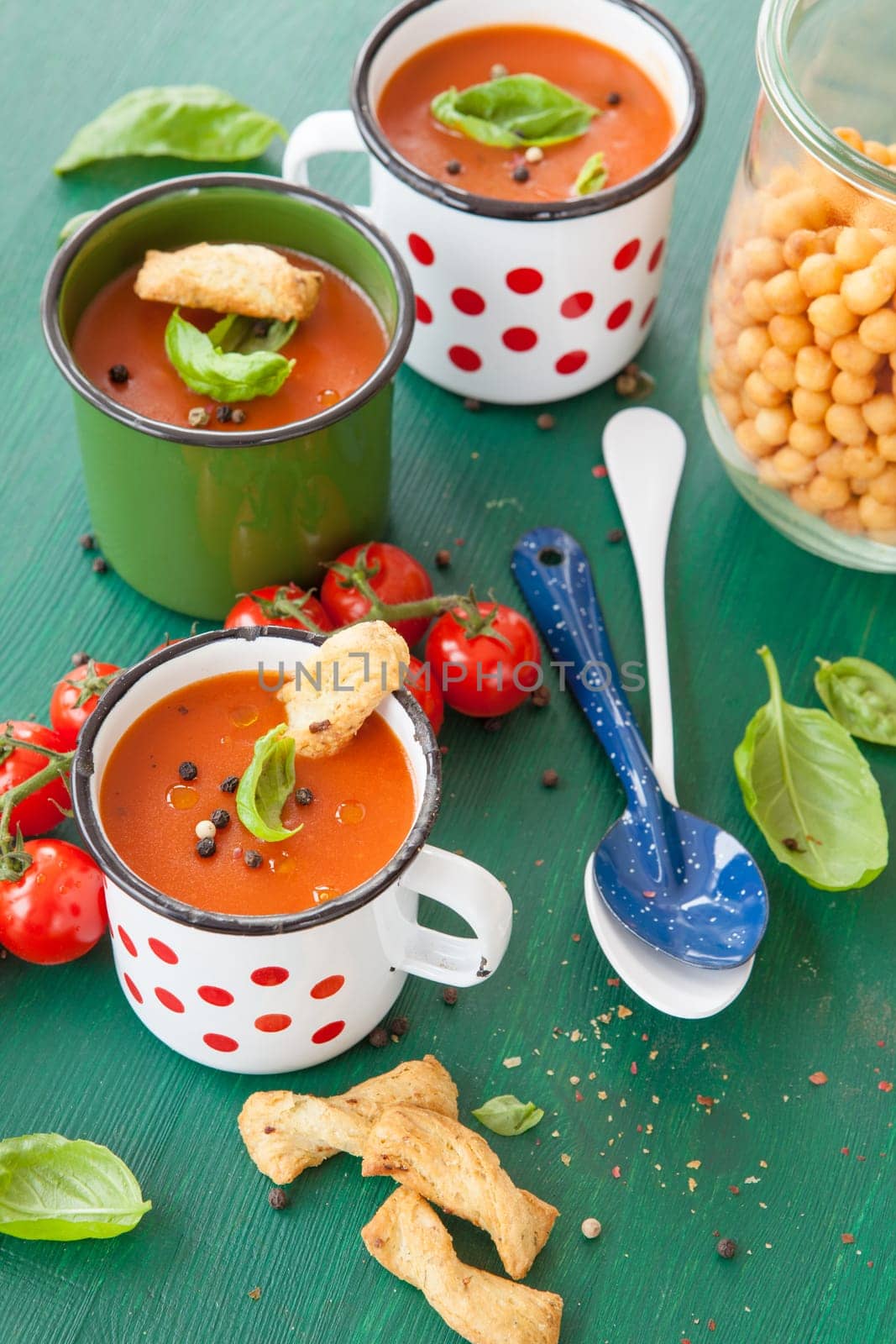 Fresh tomato soup with basil in rustic cup