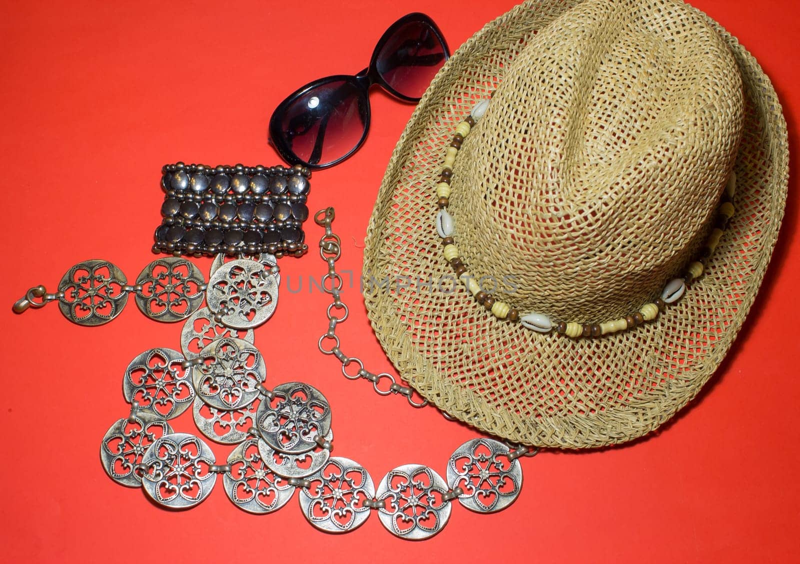 The stylish summer beach accessories. Vacation mood. Straw hat, sunglasses, belt and a bracelet.