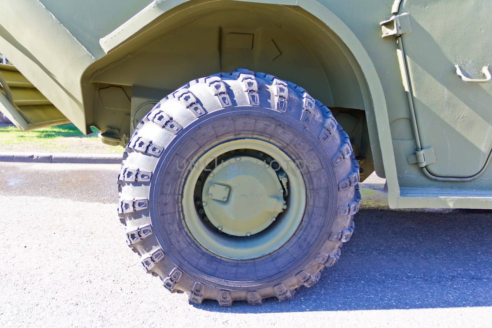 Wheel of military machine at the exhibition under open sky