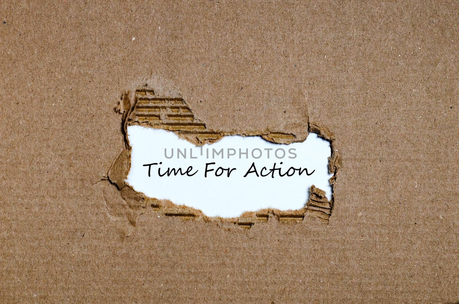 The word time for action appearing behind torn paper