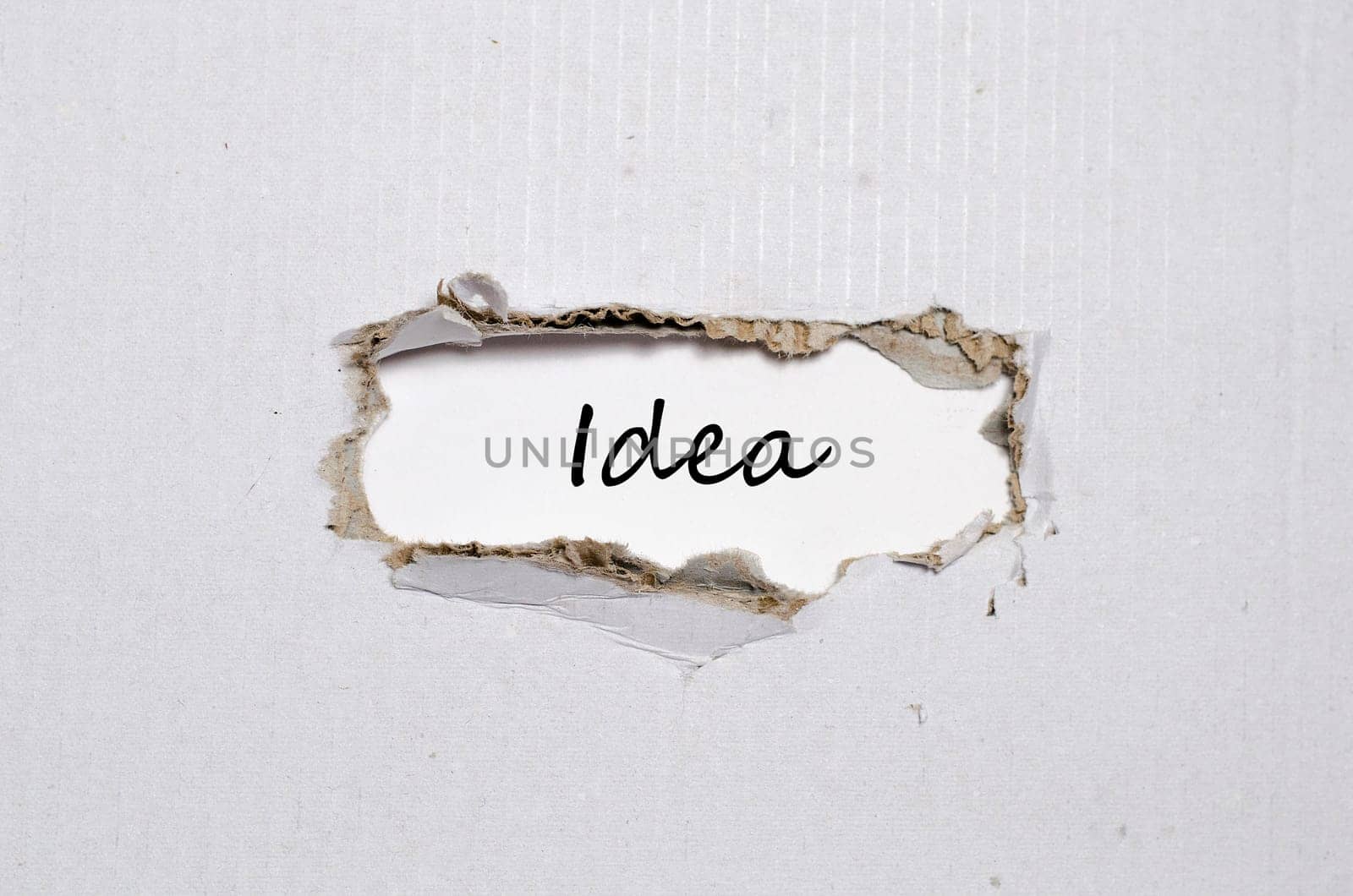The word idea appearing behind torn paper