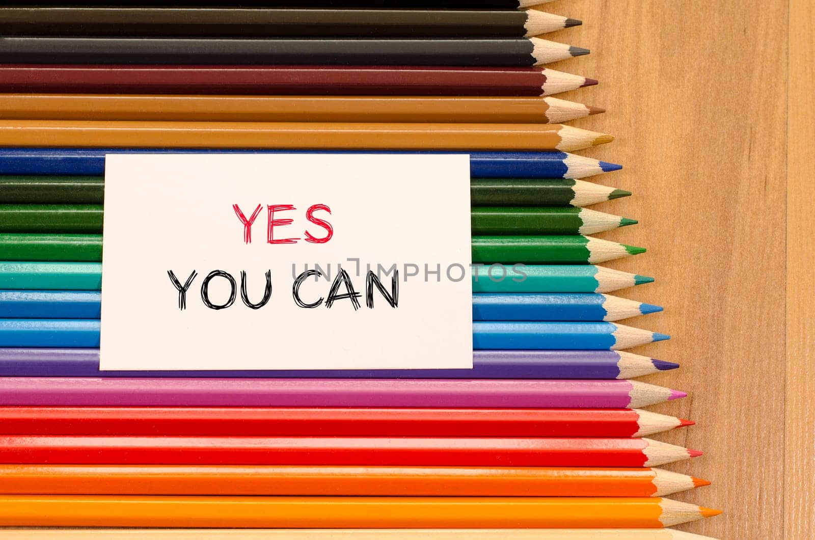 Blank white paper and colored pencil on wooden background