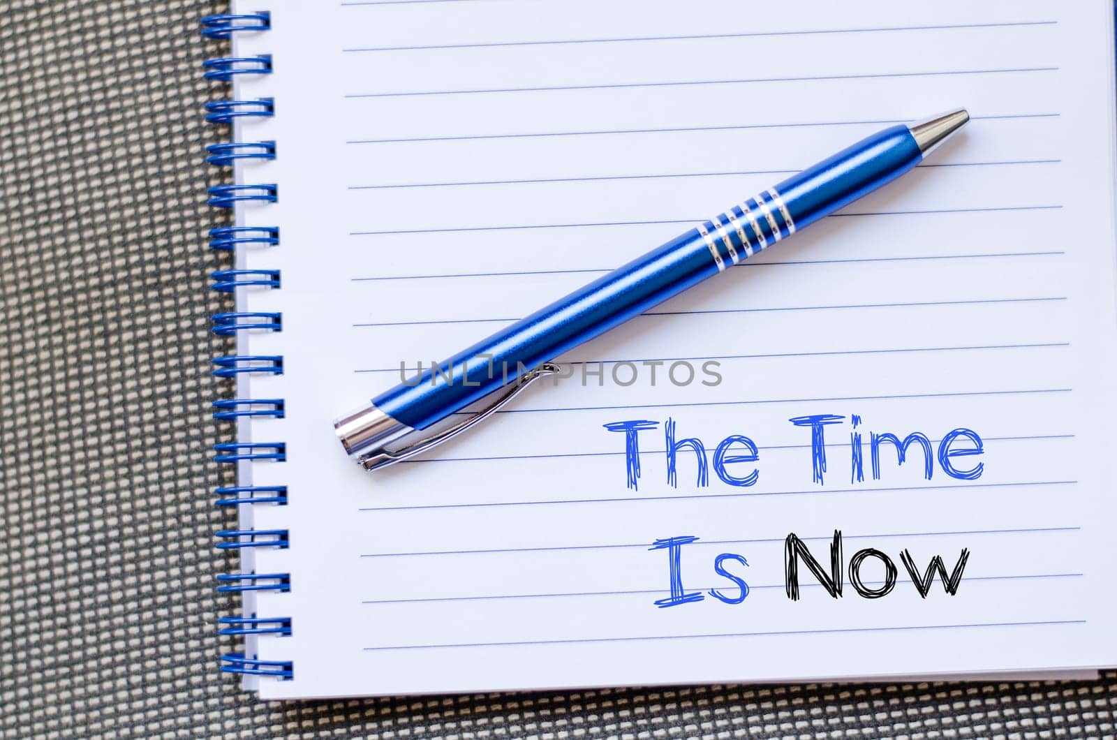 The time is now text concept write on notebook