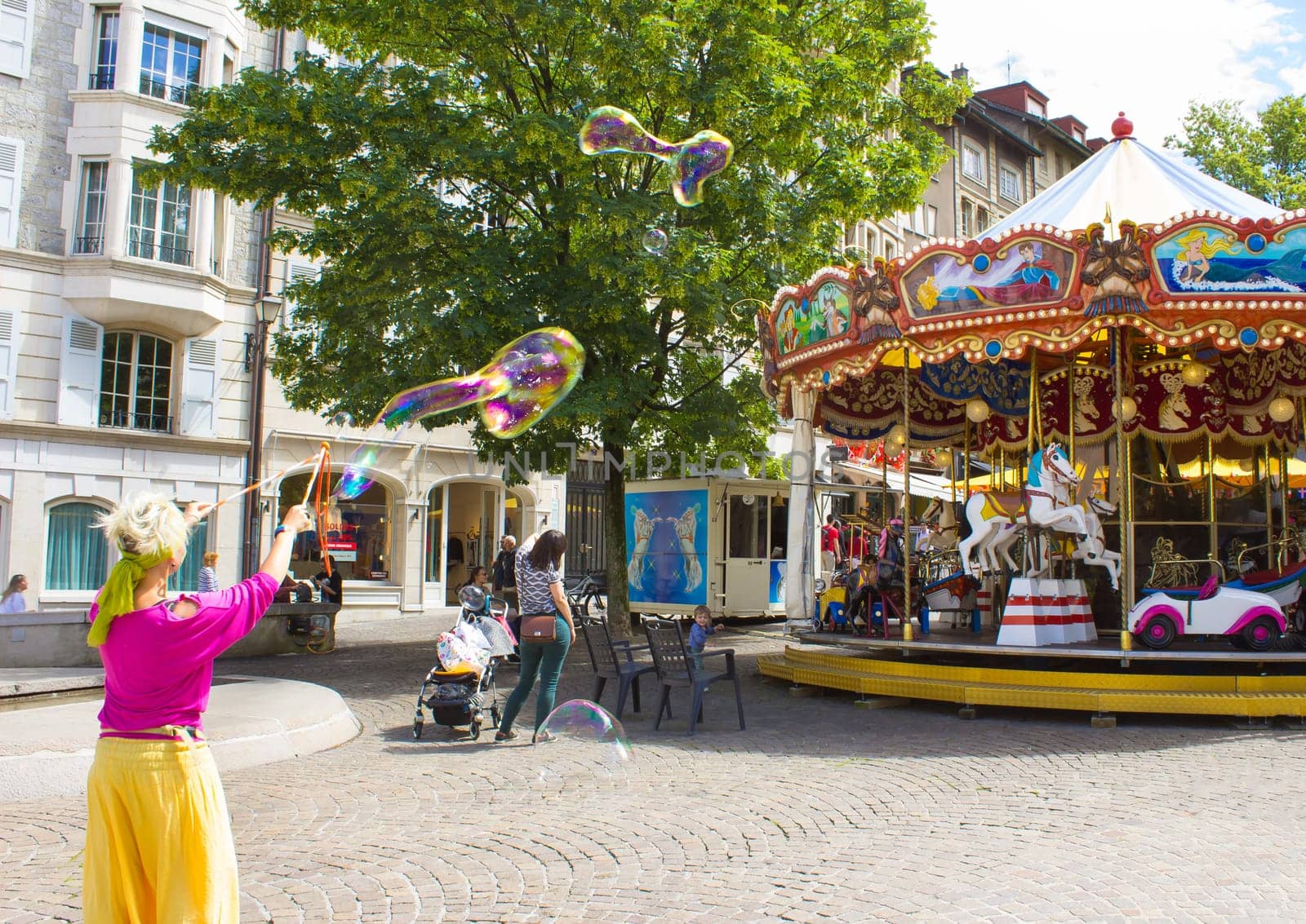 Geneva, Switzerland - June 17, 2016: The children and with soap bubbles attraction near the city carousel in the old town of Geneva, Switzerland on 28 July, 2010. It is the second most populous city in Switzerland.