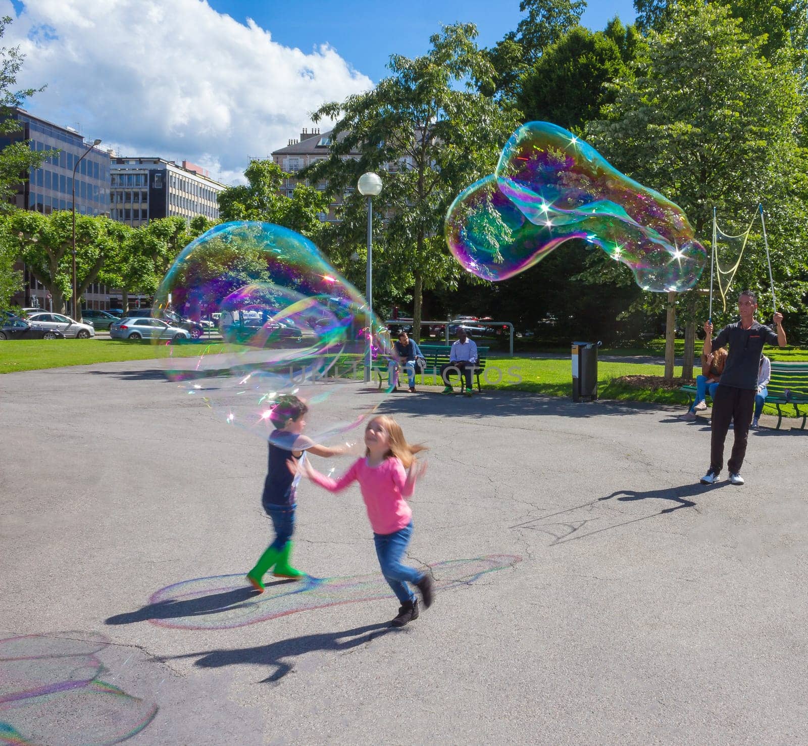 Geneva, Switzerland - June 17, 2016: The children and with soap bubbles attraction at park in the old town of Geneva, Switzerland on 28 July, 2010. It is the second most populous city in Switzerland.