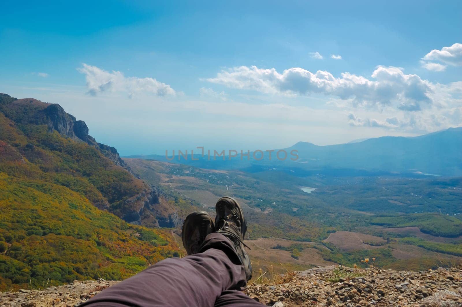 Hiker sitting on the top of the mountain. Mountains in Crimea at the sunny summer day.