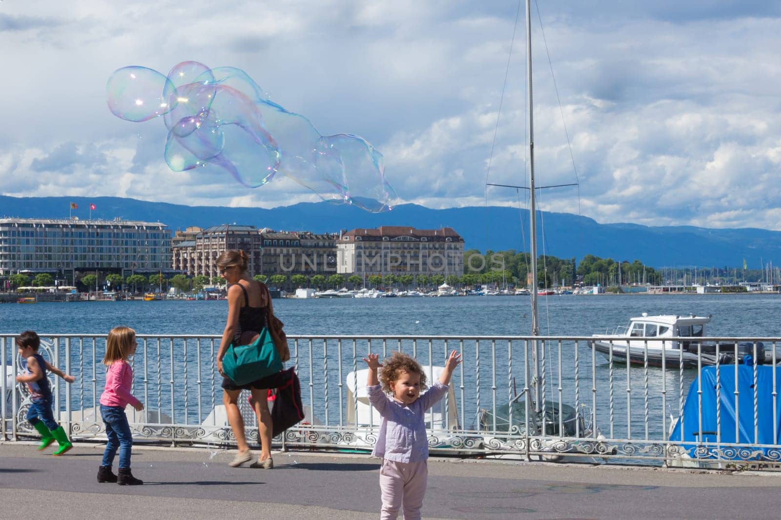 Geneva, Switzerland - June 17, 2016: The children and with soap bubbles attraction at Lake promenade in the old town of Geneva, Switzerland on 28 July, 2010. It is the second most populous city in Switzerland.