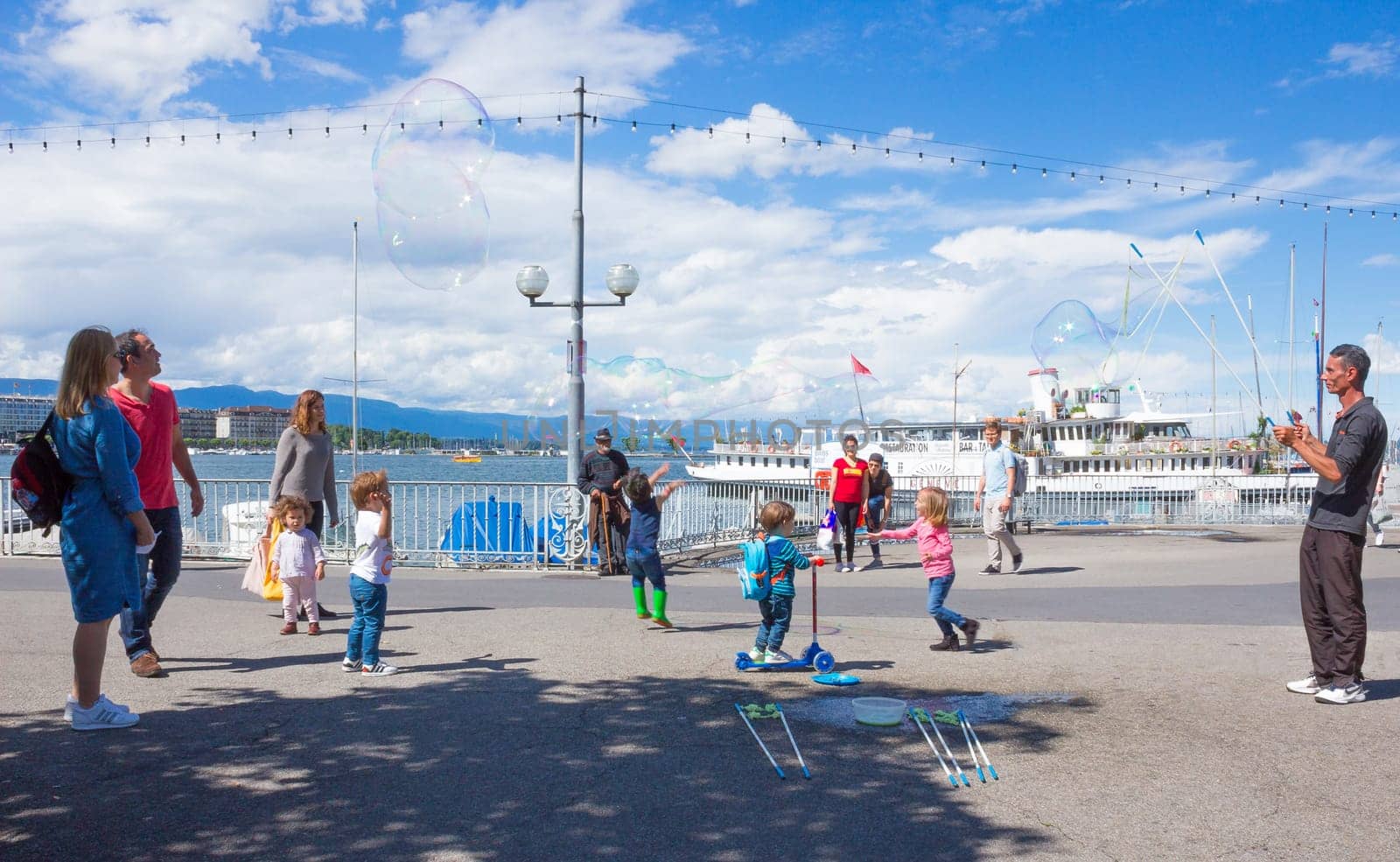 Geneva, Switzerland - June 17, 2016: The children and with soap bubbles attraction at Lake promenade in the old town of Geneva, Switzerland on 28 July, 2010. It is the second most populous city in Switzerland.