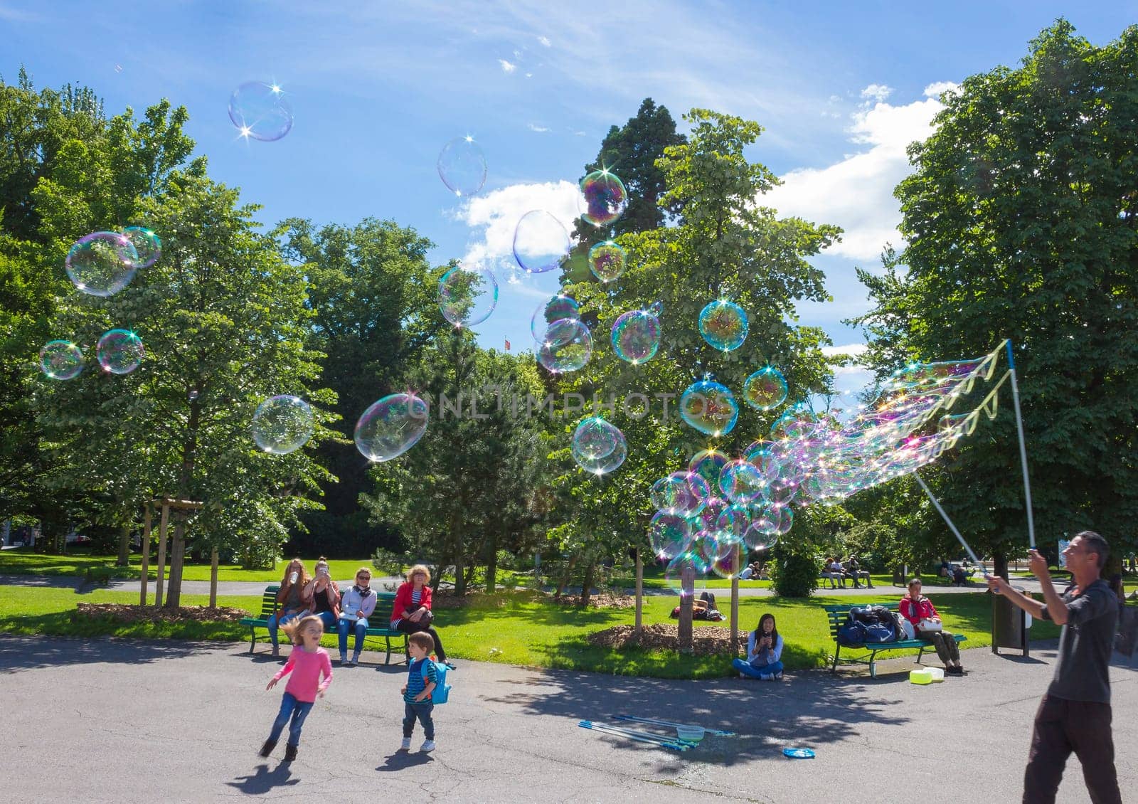 Geneva, Switzerland - June 17, 2016: The children and with soap bubbles attraction at park in the old town of Geneva, Switzerland on 28 July, 2010. It is the second most populous city in Switzerland.