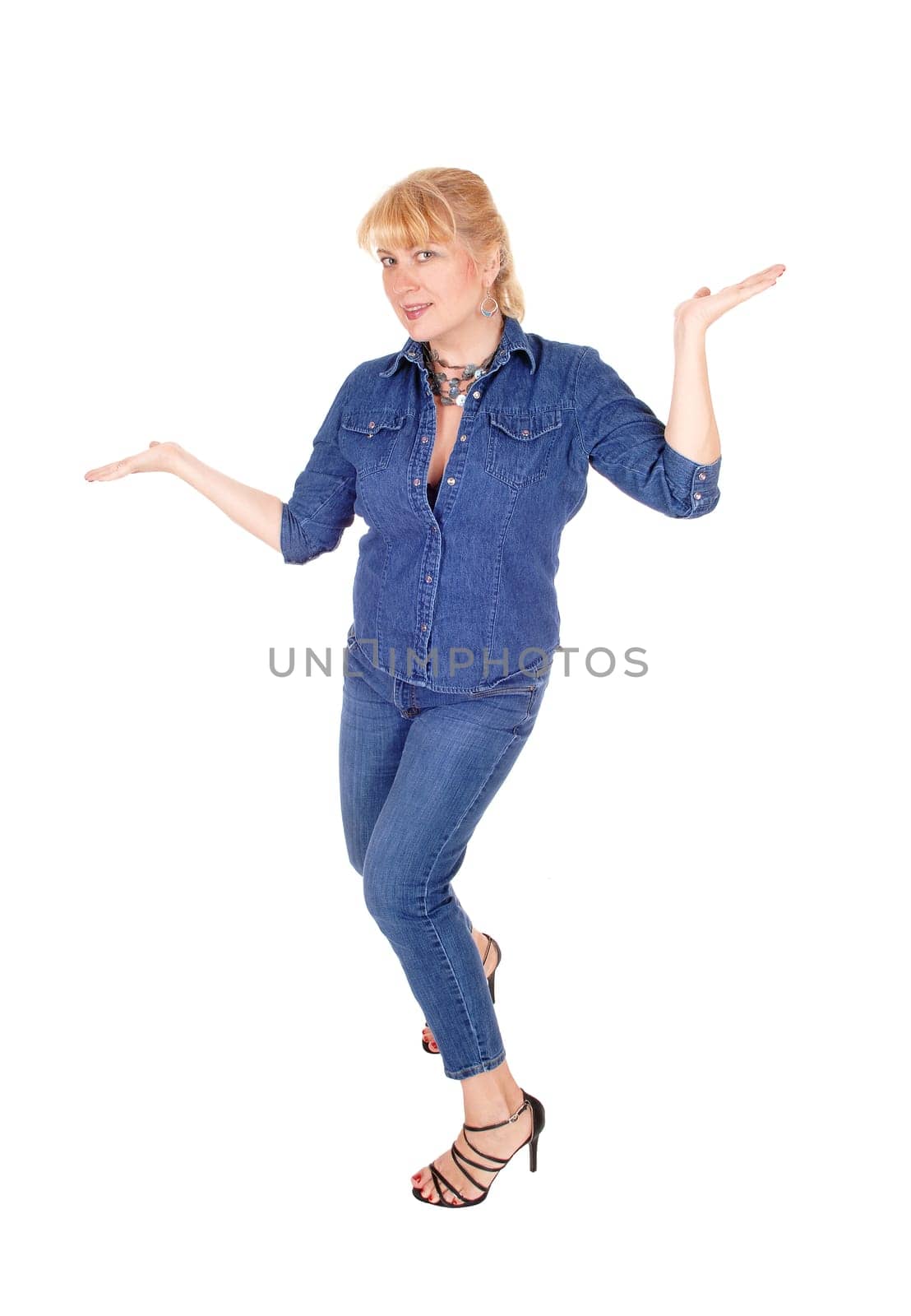 A lovely woman in jeans and jeans jacket standing isolated for white .background gesturing with her hands..