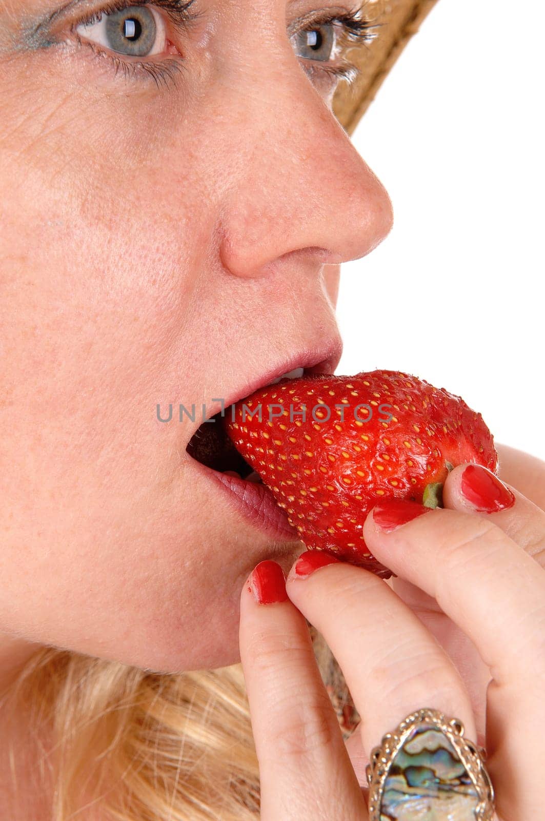 A closeup image of a nice woman eating a big strawberry with blue eye's.isolated for white background..