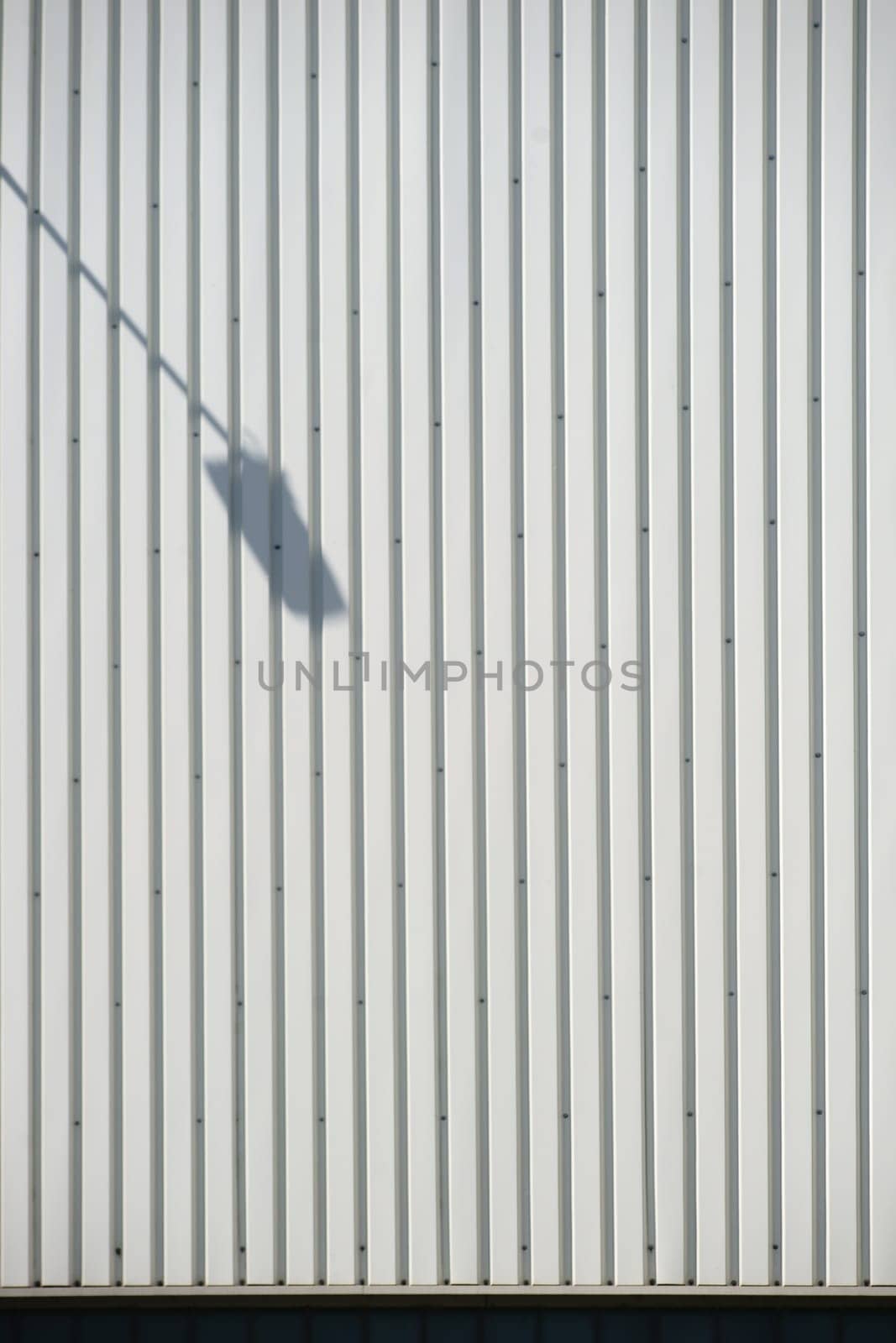 The close-up of a façade made of corrugated iron panels with a lantern shade.