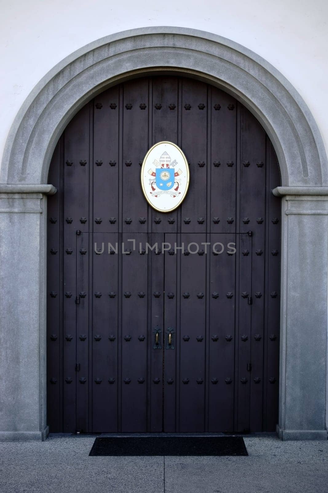 San Juan Capistrano,United States - December 25,2015: The heavy iron-shod front door of the Mission Basilica of San Juan Capistrano with coat of arms on December 25,2015 in San Juan Capistrano.