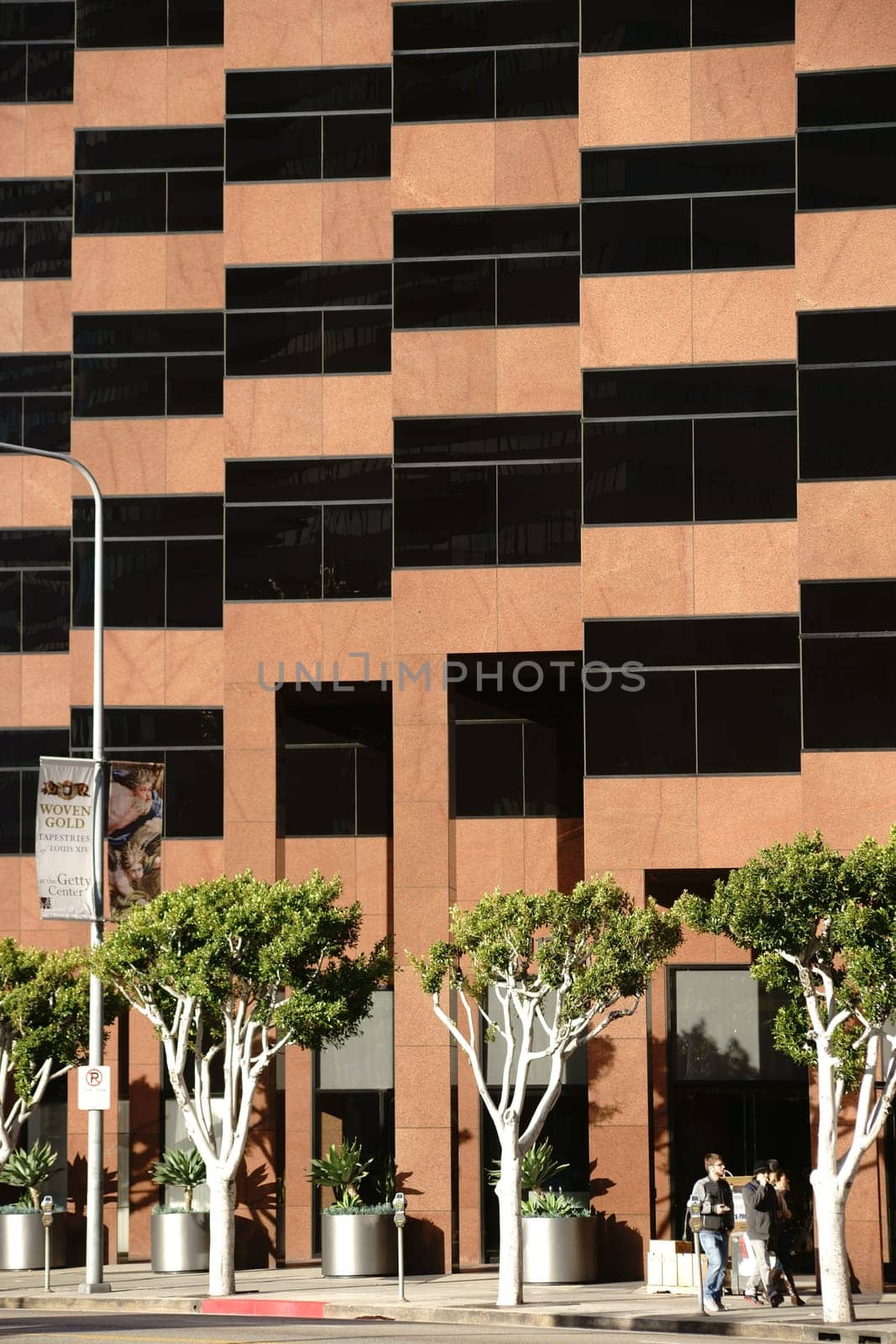 Los Angeles,United States - December 27,2015: Pedestrians pass through a modern shopping center with ornamental trees on Wilshire Boulevard on December 27,2015 in Los Angeles.