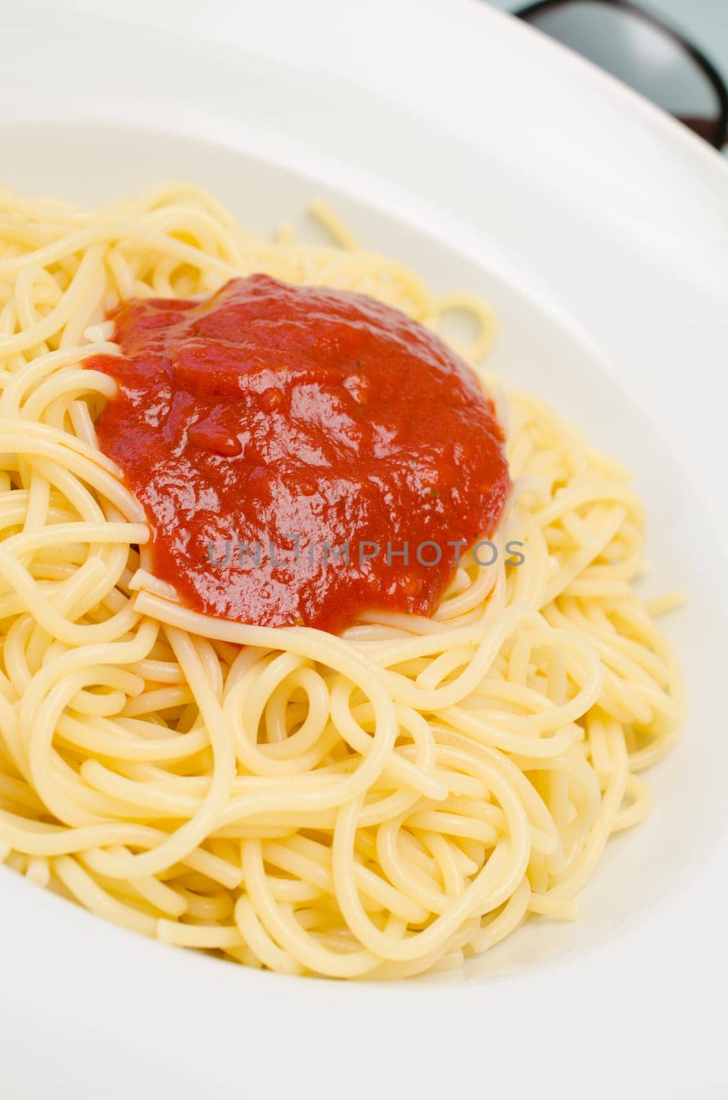 Delicious spaghetti with tomato sauce on a white plate