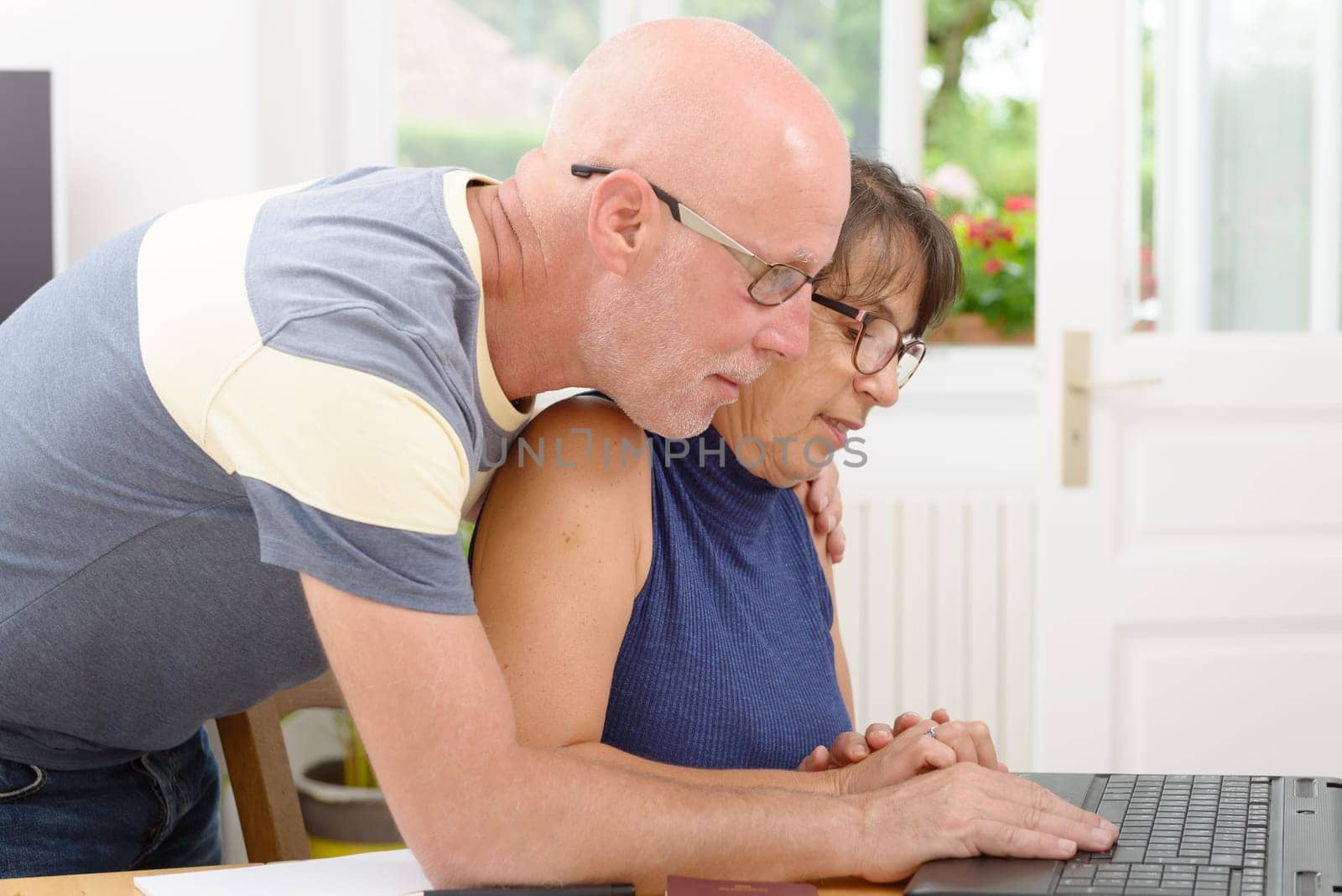 a mature couple with a laptop in home