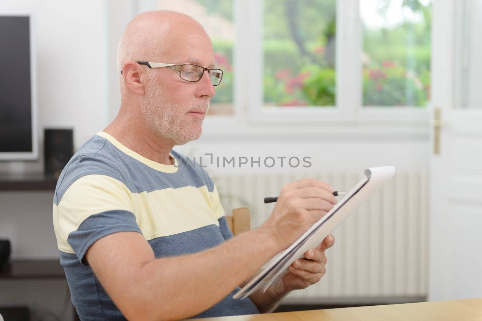 a mature man with glasses taking notes