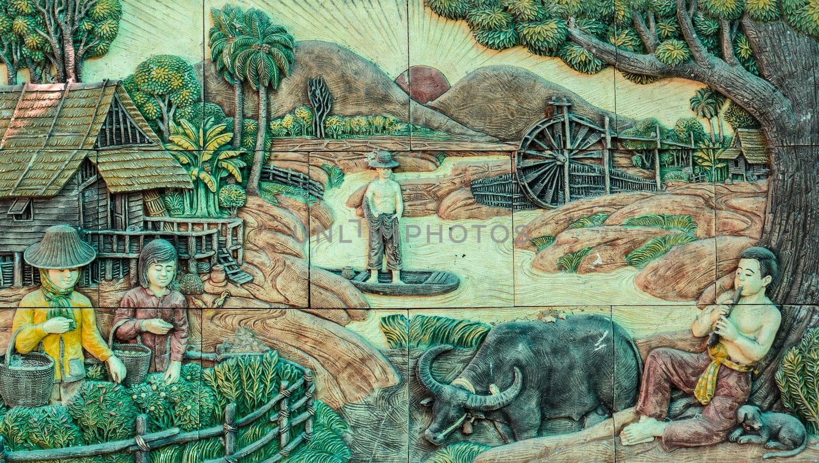 Thai stucco art of traditional Thai rural culture life on temple wall in Bangkok, Thailand