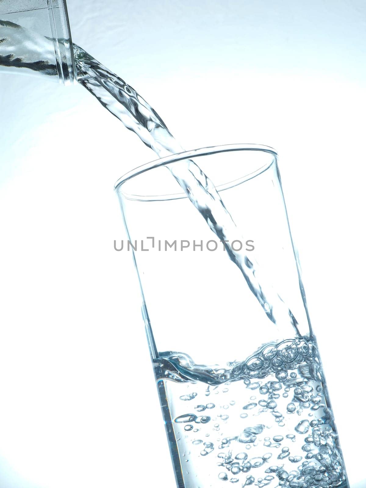 Pouring fresh table water toned in blue, healthy food concept