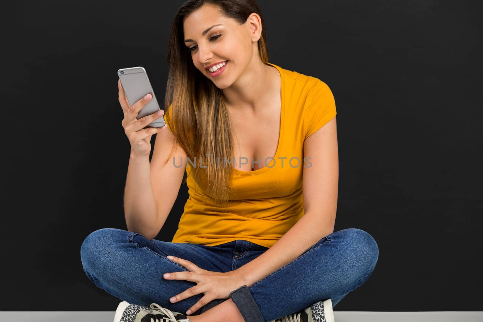 Beautiful woman lying in the floor and texting a sms