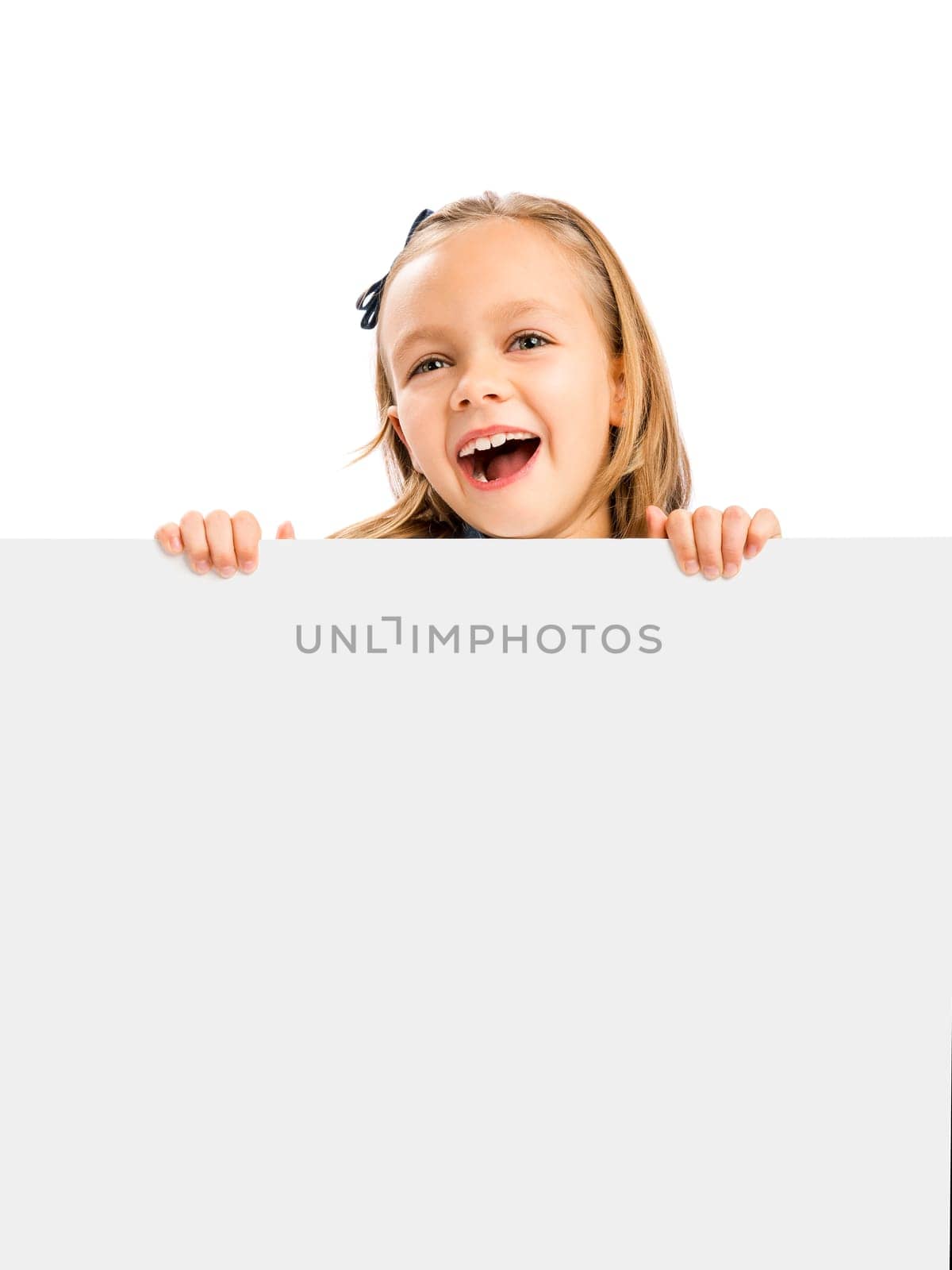 Beautiful little girl holding and showing something on a whiteboard