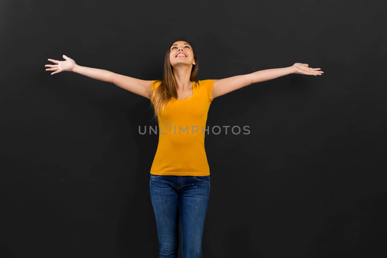 Beautiful woman in front of a black wall with a thoughtful expression