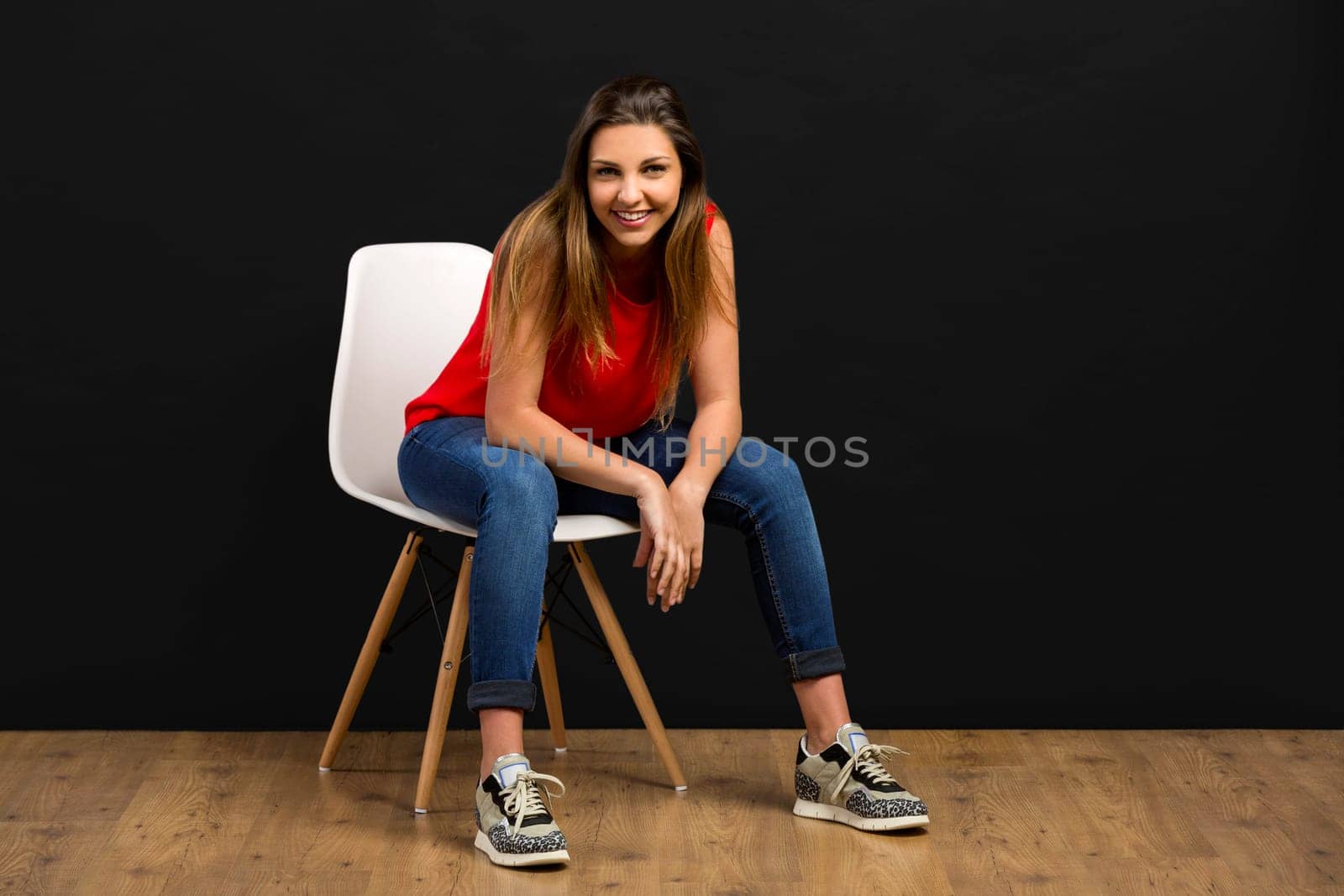 Beautiful young woman sitting on chair and smiling