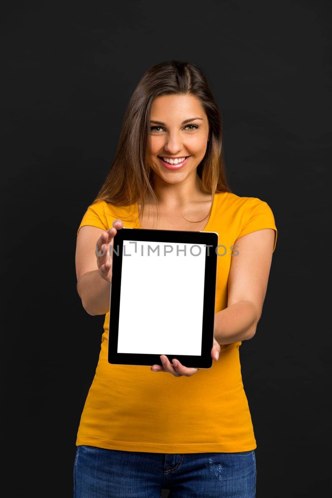Beautiful woman sitting on the floor working with a tablet