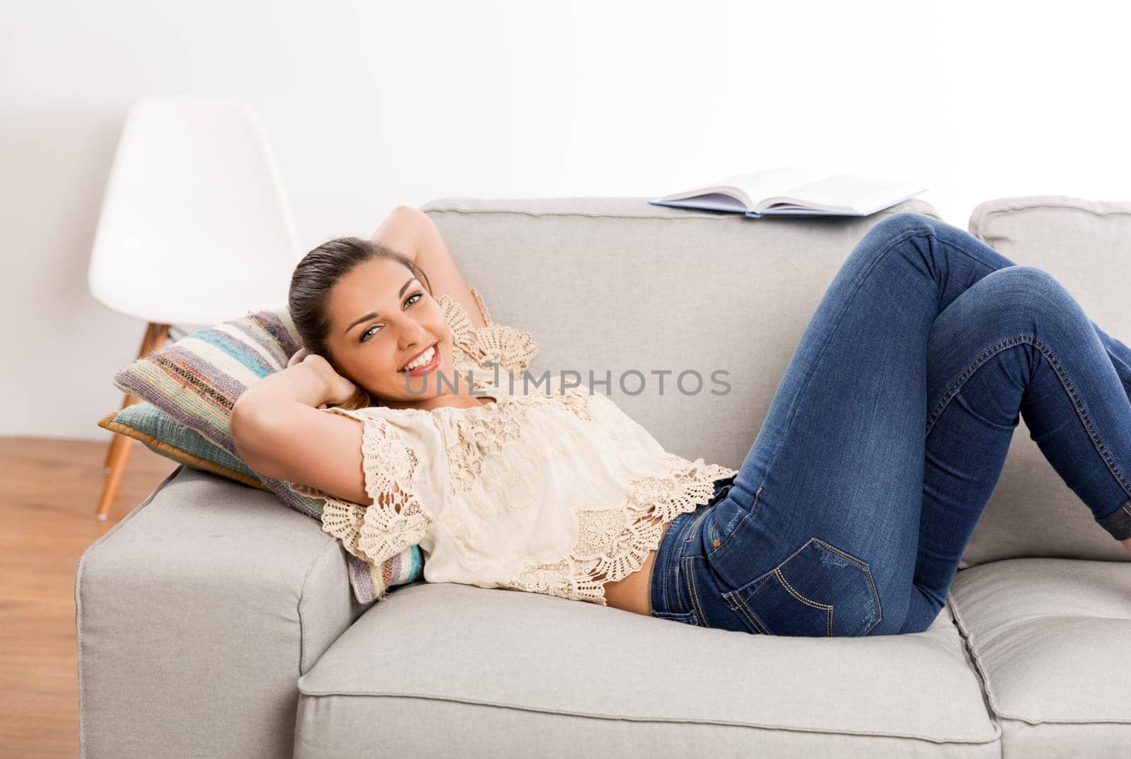 Beautiful woman at home listening music and dancing over the couch