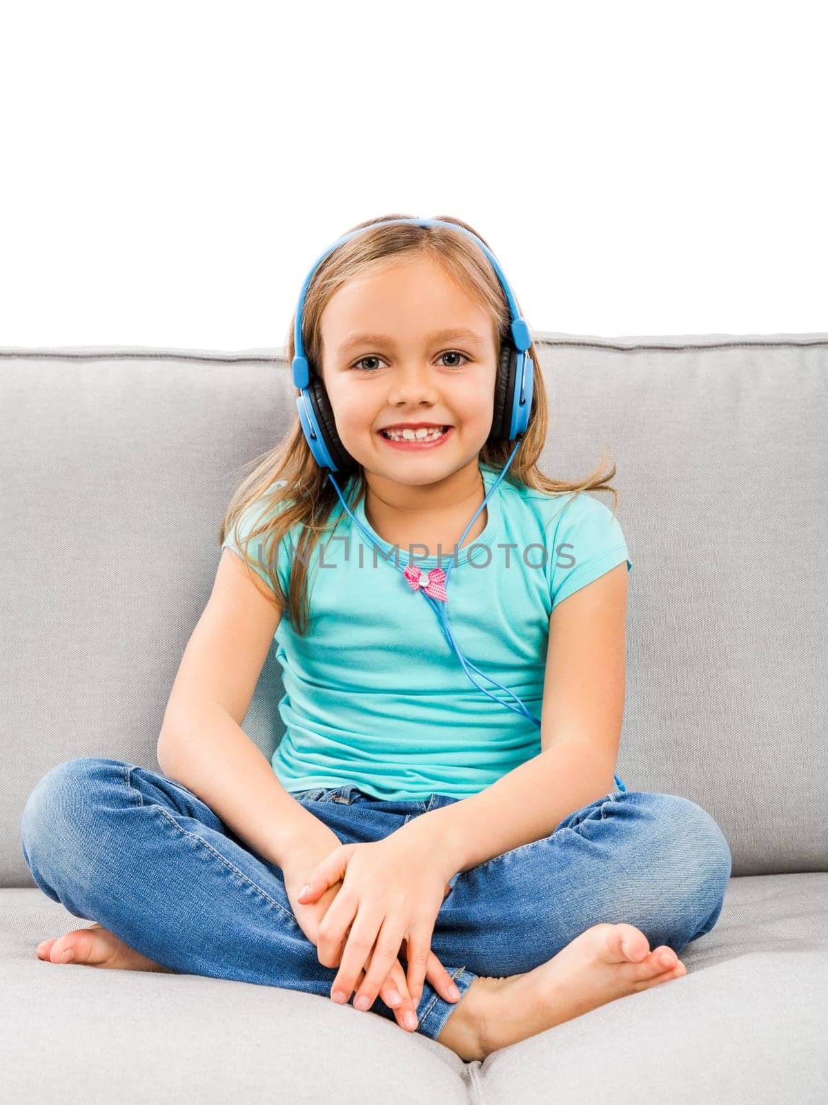 Little blonde girl at home listen music with headphones