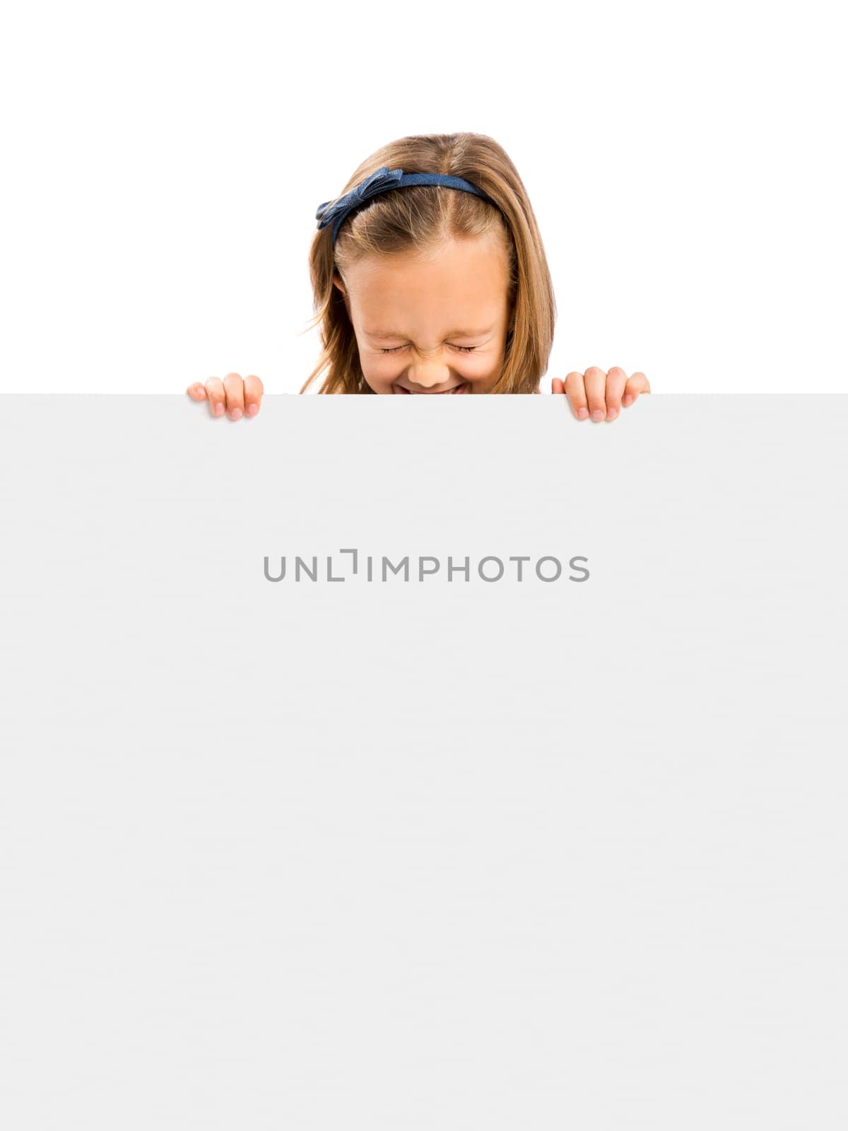 Beautiful little girl holding and showing something on a whiteboard