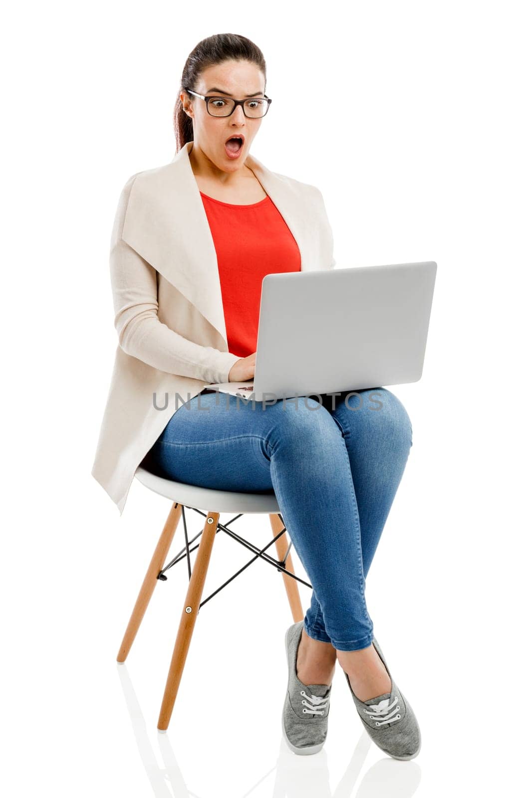 Beautiful and happy woman working with a laptop, isolated over white background