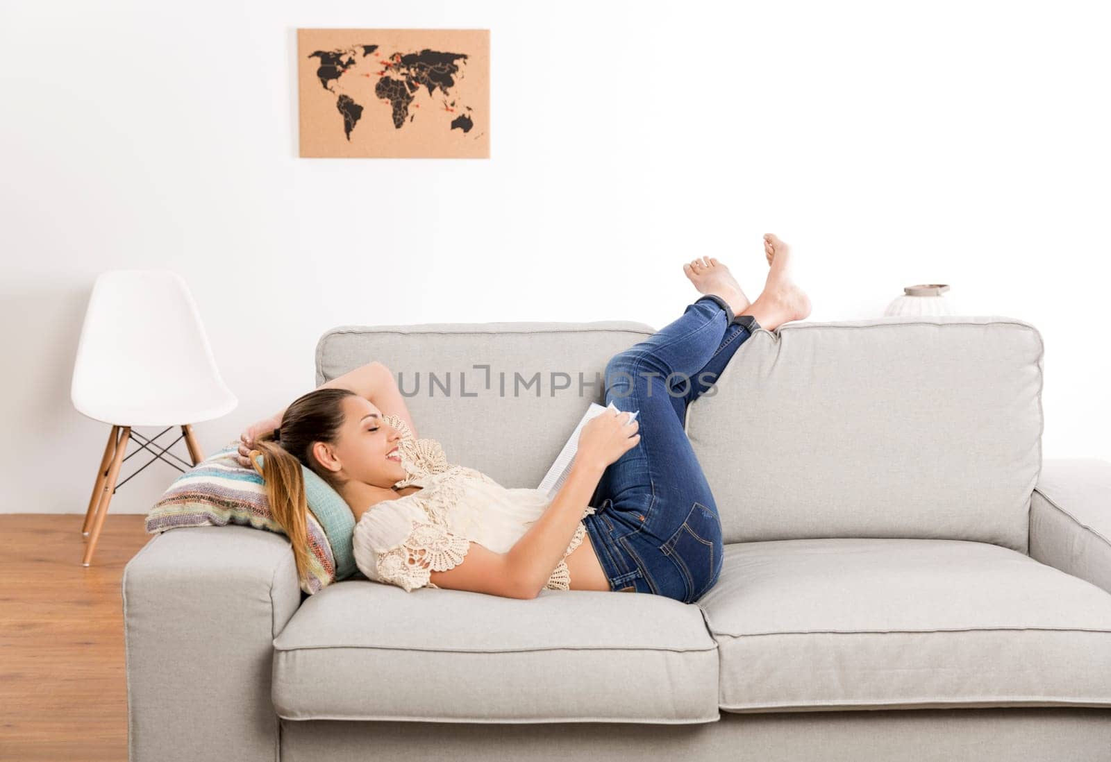 Beautiful woman at home sitting on the couch and reading a book
