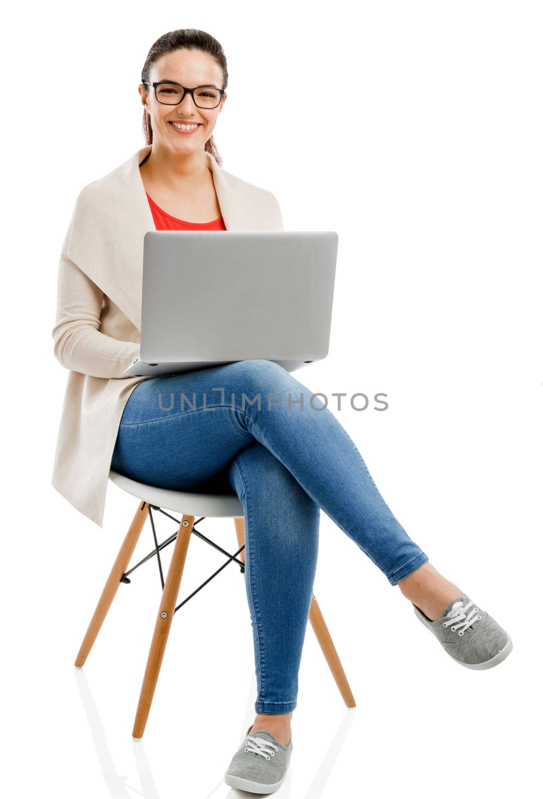 Beautiful and happy woman working with a laptop, isolated over white background