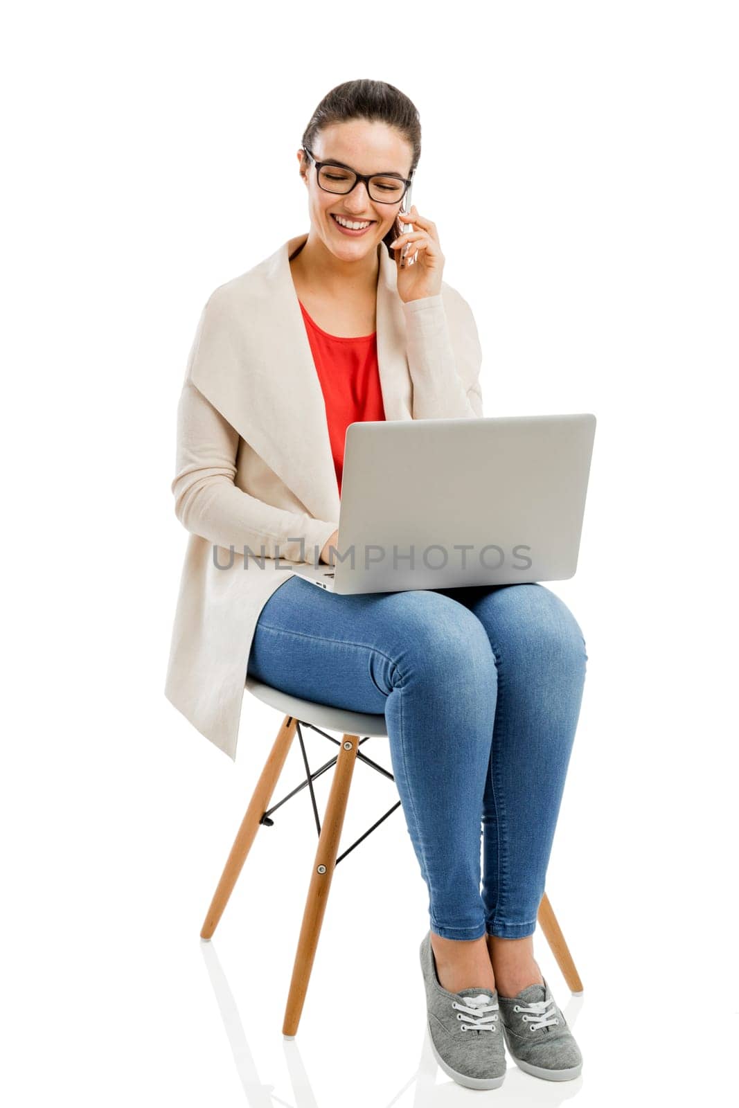 Beautiful and happy woman working with a laptop, isolated over white background
