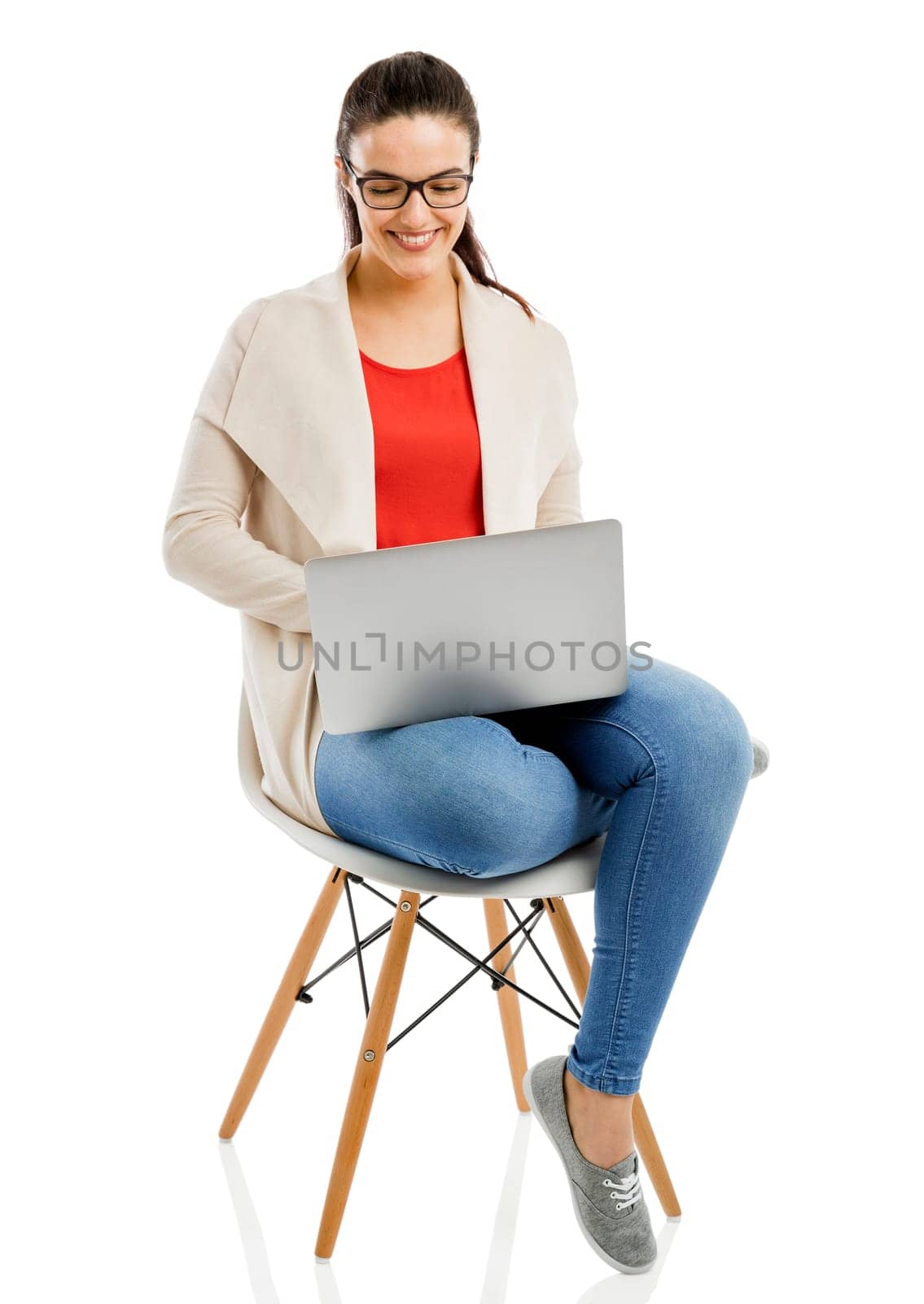 Beautiful and happy woman working with a laptop, isolated over white background