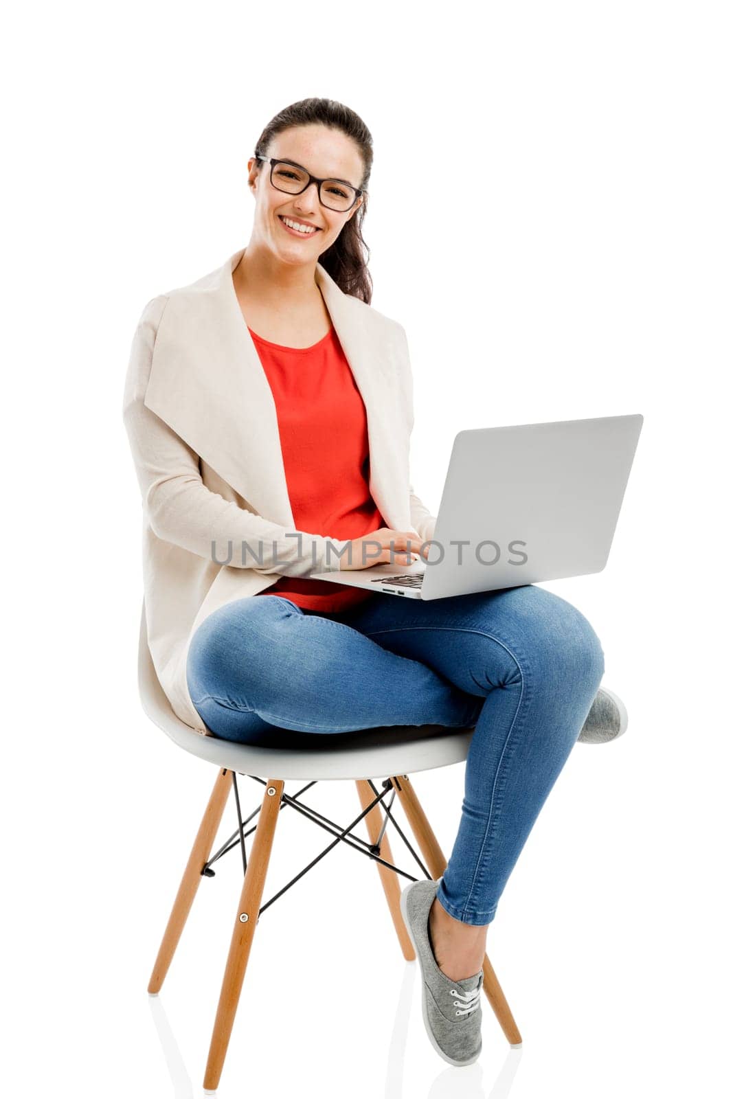 Beautiful and happy woman working with a laptop, isolated over white background