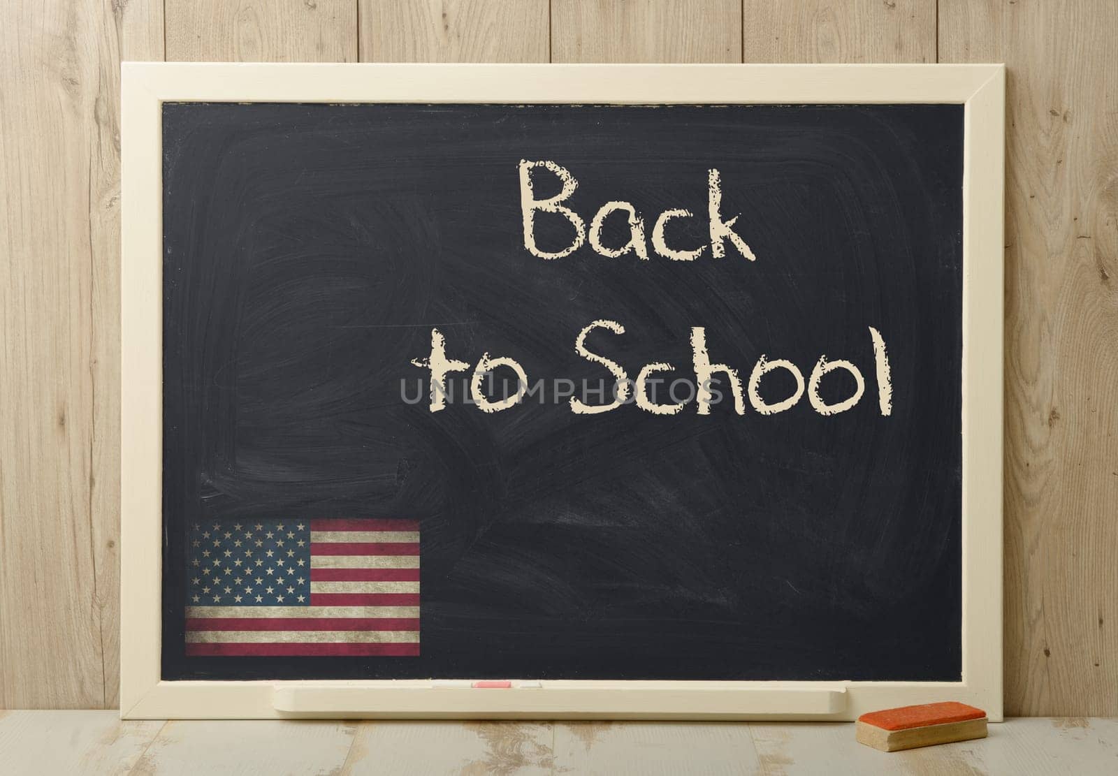 back to school written on blackboard with American flag