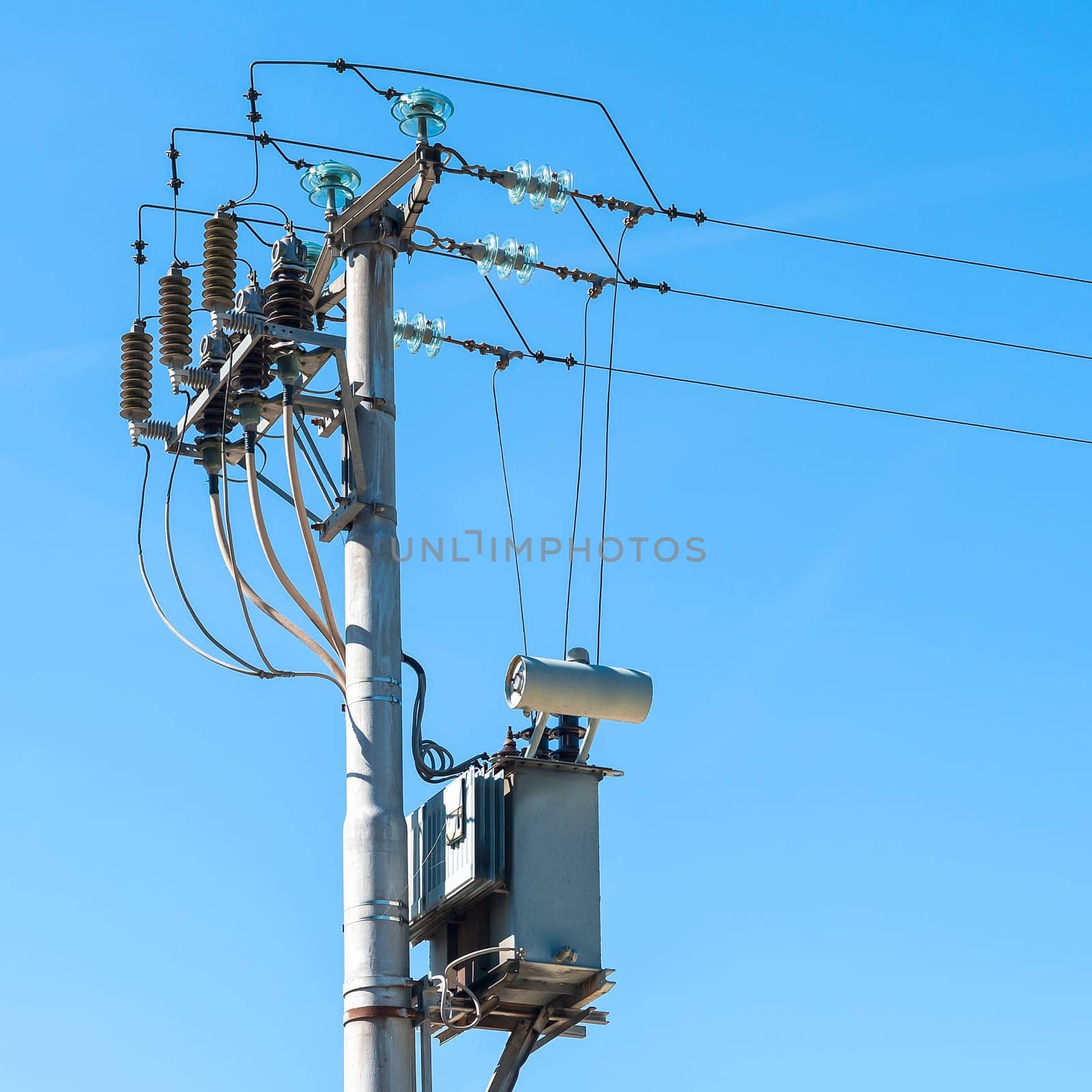 Electrical transformer to electrical pylon against the blue sky