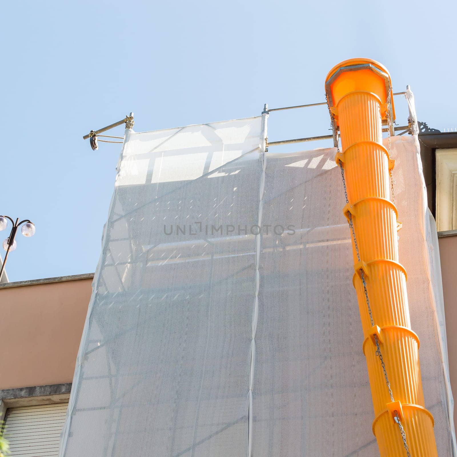 Scaffolding covered with modular slide for debris and rubble