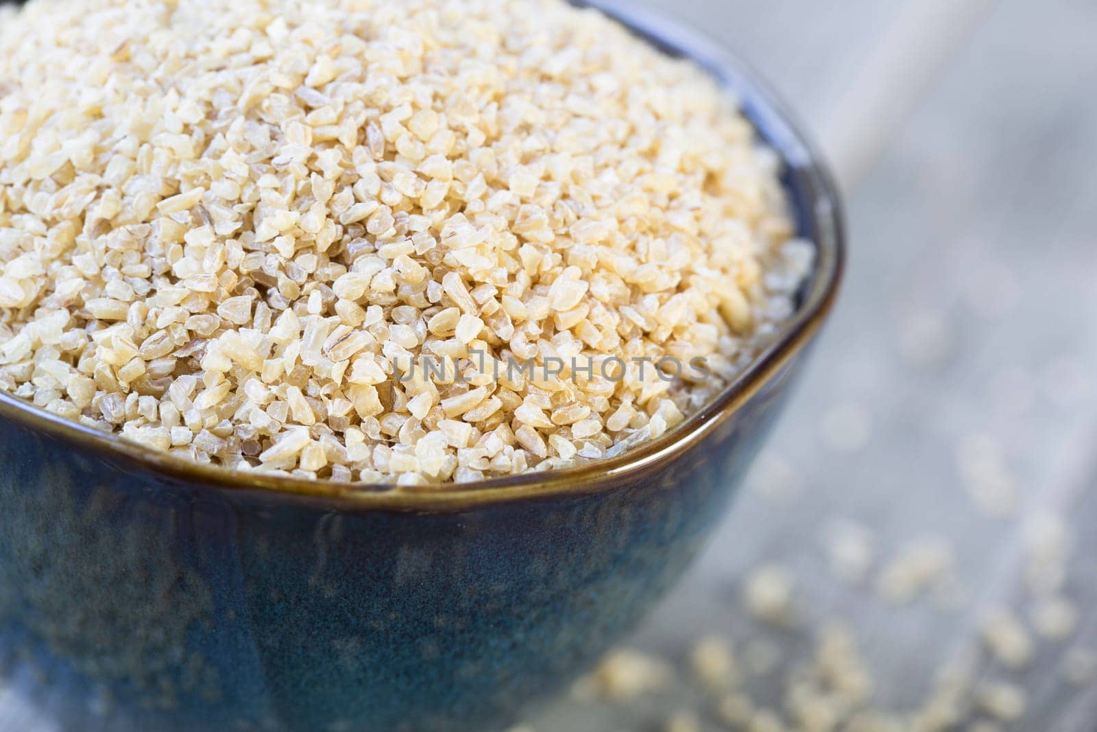 Bowl of dried bulgar wheat in rustic setting.